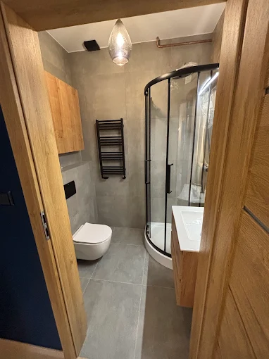 Łazienka z Zaokrągloną Kabiną - Kompaktowa łazienka z oryginalną kabiną prysznicową | PROFESA BUD - Remonty i wykończenia wnętrz Warszawa