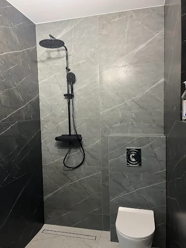 Łazienka Nowoczesna - Grafit - Elegancka łazienka z dużym kafelkami i czarnymi akcentami | PROFESA BUD - Remonty i wykończenia wnętrz Warszawa